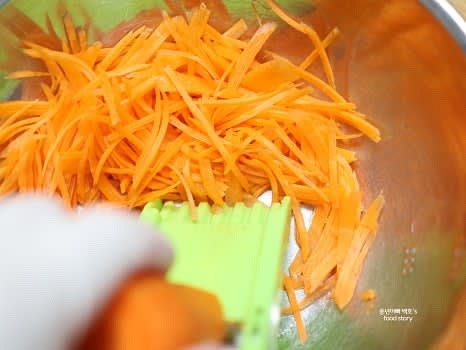당근 2개를 깨끗이 씻고 껍질을 벗긴 뒤 채칼을 사용해 얇게 채를 썰어줍니다.