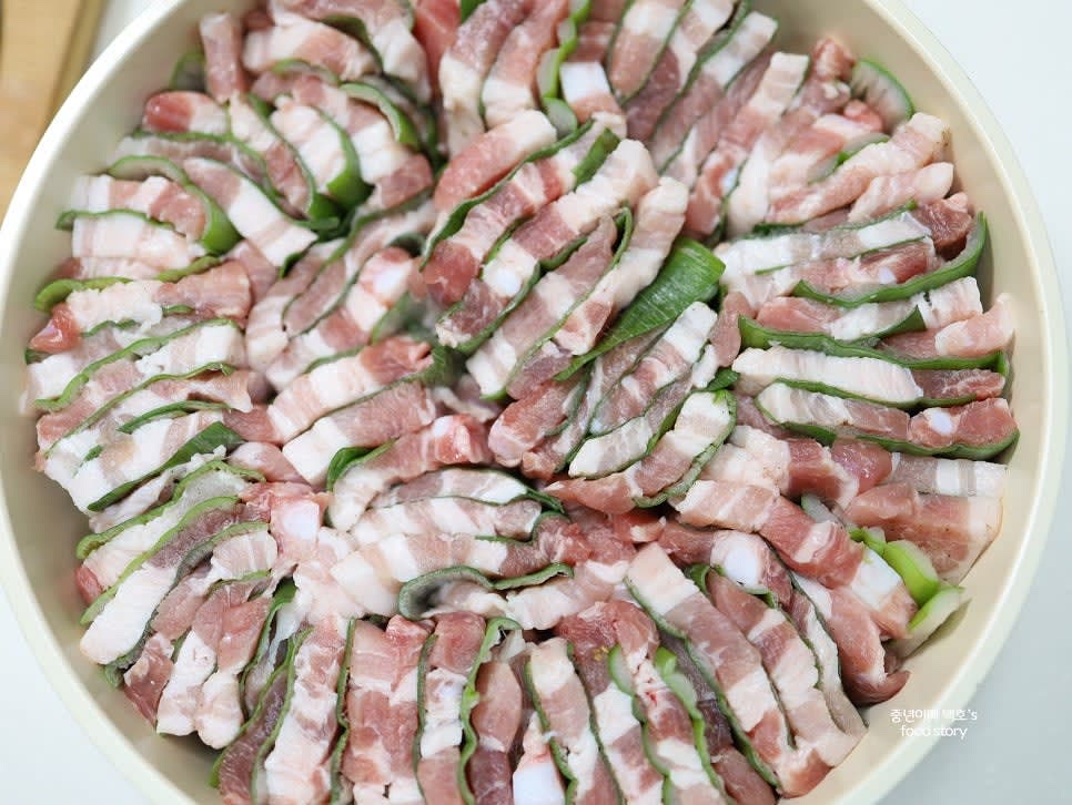 겹겹이 쌓은 삼겹살과 대파를 냄비에 넣고, 청주 3스푼을 추가합니다.