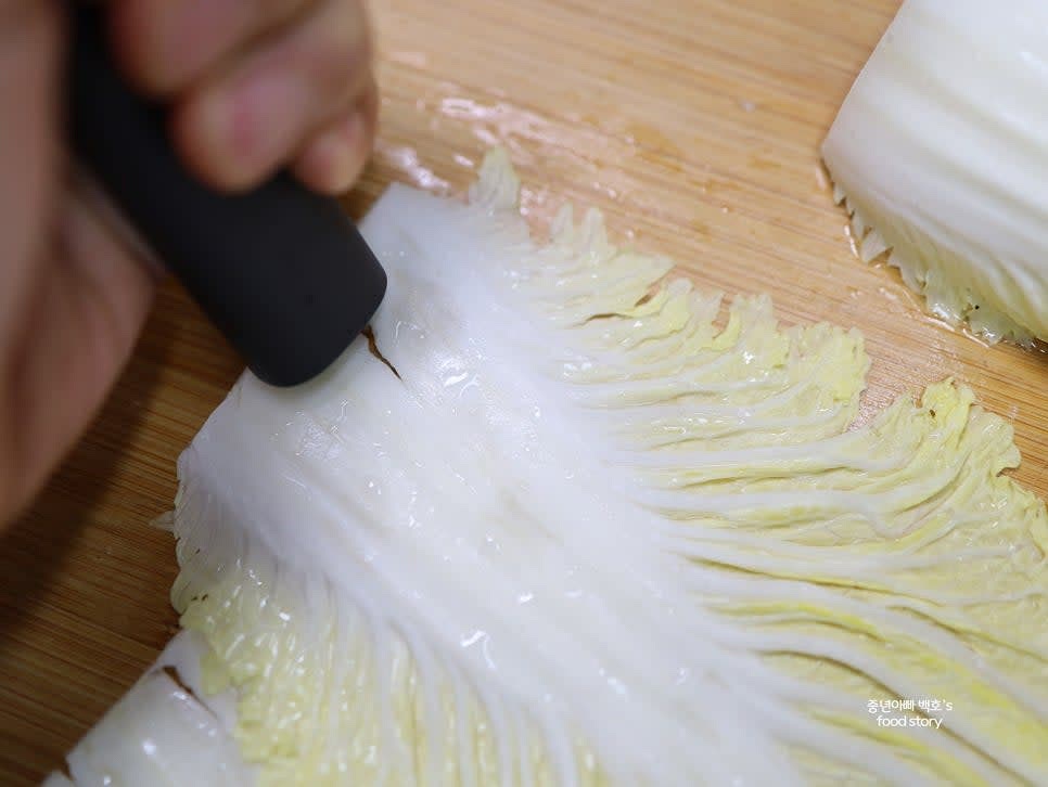 배춧잎 줄기 부분을 칼 손잡이나 단단한 도구로 두드려 펴줍니다.