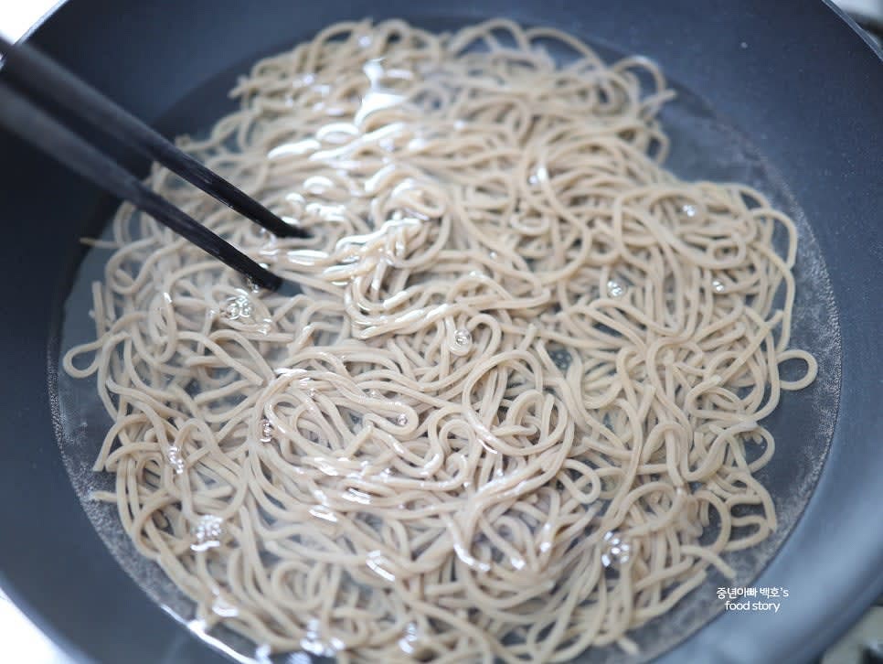 냉동 메밀면을 끓는 물에 넣고 약 1분간 삶은 뒤, 찬물에 헹구어 전분기를 제거합니다.
