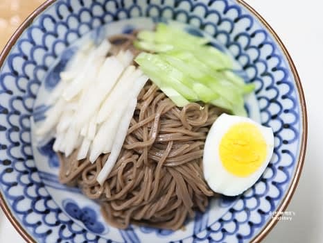 물기를 제거한 면을 그릇에 담고, 준비한 오이, 동치미 무, 삶은 달걀을 고명으로 올립니다.