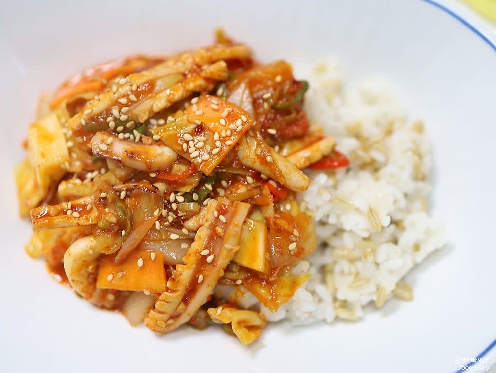 밥 한 공기를 그릇에 담고, 볶은 오징어를 밥 위에 올려 덮밥으로 완성합니다.