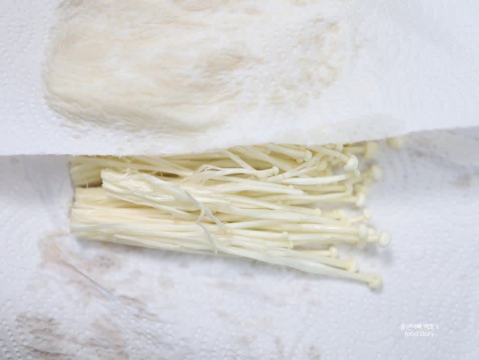 팽이버섯의 밑동을 자르고 흐르는 물에 가볍게 씻은 후 종이타월로 물기를 제거합니다.