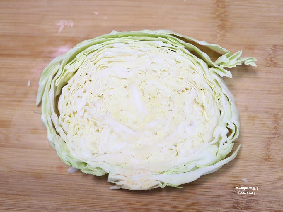 양배추를 심지를 중심으로 반으로 자른 뒤 약 2센티 두께로 원형으로 썹니다.