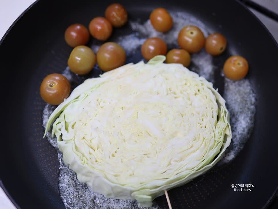 팬에 양배추와 방울토마토를 넣고 앞뒤로 노릇노릇하게 구우면서 소금과 후추를 뿌립니다.