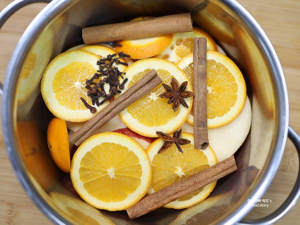 깊은 냄비에 슬라이스한 과일과 시나몬 스틱, 팔각, 정향을 넣습니다.