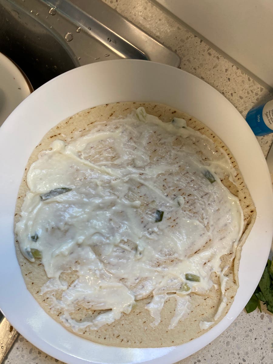 Spread tzatziki across souvlaki bread