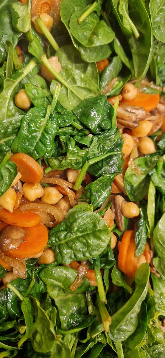Gib den Blattspinat in die Pfanne und brate ihn, bis er zusammenfällt.