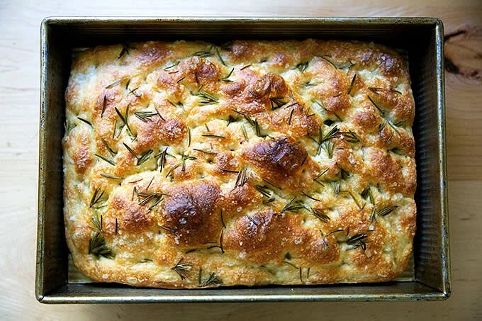 Bake for 25 to 30 minutes, until the underside is golden and crisp. Remove and transfer the focaccia to a cooling rack. Let it cool for 10 minutes before cutting and serving; let it cool completely if you are halving it with the intention of making a sandwich.