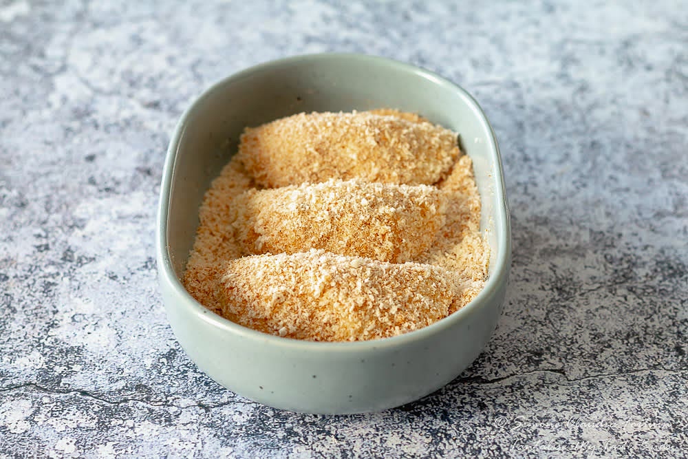 Dip in the milk and then in the breadcrumbs.