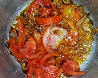 Slice the tomatoes and add to the browned onions. Add salt and leave to cook.