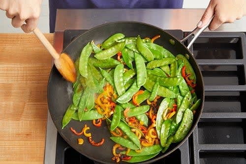 While the rice cooks, in a large pan (nonstick, if you have one), heat 1 tablespoon of olive oil on medium-high until hot. Add the sliced peppers and snow peas; season with salt and pepper. Cook, stirring occasionally, 3 to 4 minutes, or until lightly browned and slightly softened. Transfer to a bowl and add the ponzu/Worcester sauce. Stir to coat. Cover with foil to keep warm.