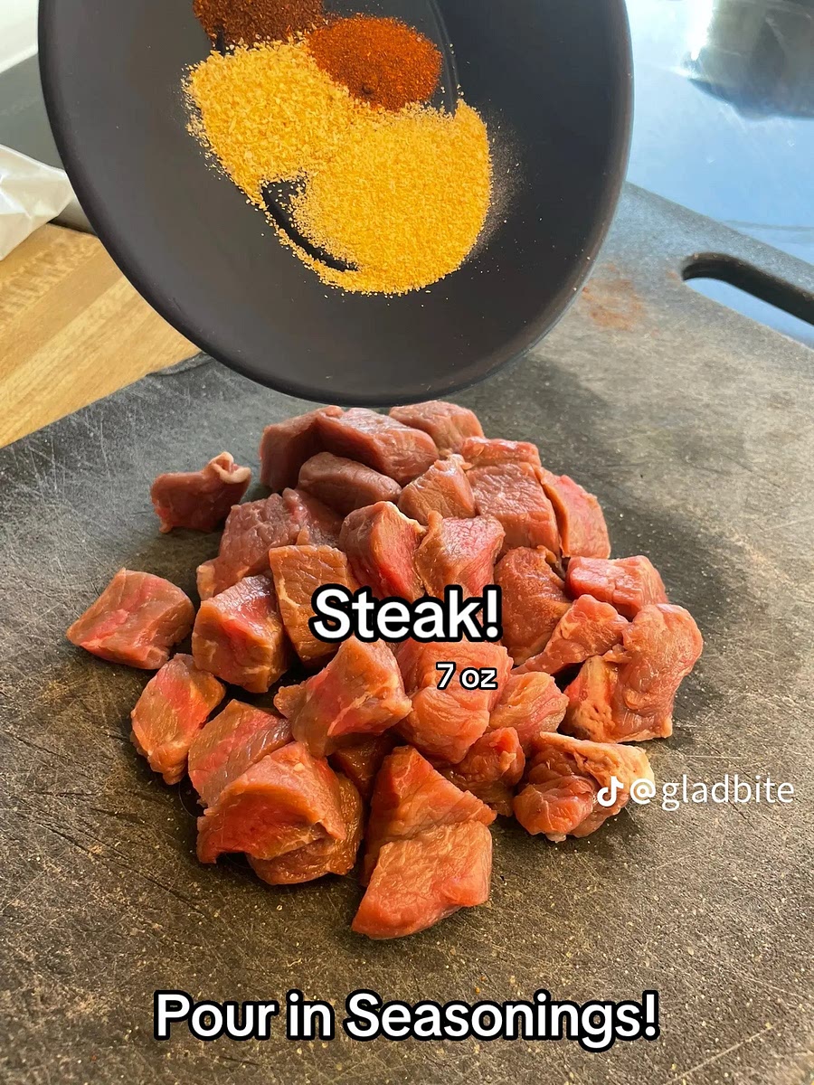 Take the seasonings and pour them on the steak cubes