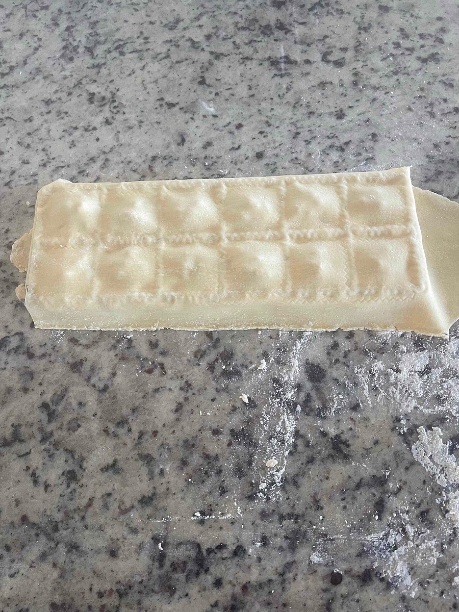 Smooth the pasta sheet with your fingertips, working around the filling to get the air bubbles out. Press to seal the edges and sides.