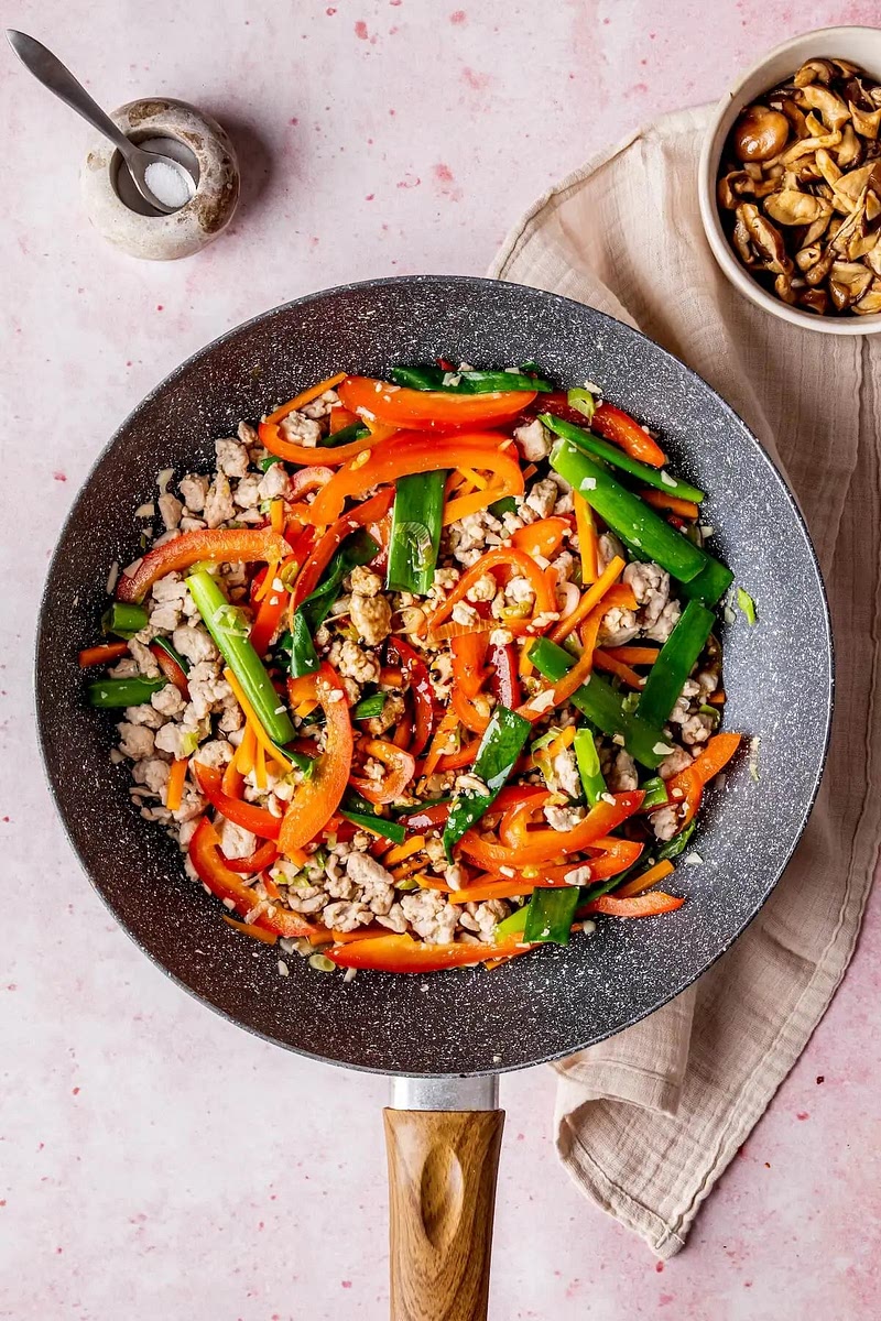 Gemüse anbraten: Karotten, Paprika und Frühlingszwiebeln hinzufügen und 3 Minuten kochen, bis sie weich sind. Knoblauch hinzufügen und weitere 2 Minuten kochen, bis er duftet.