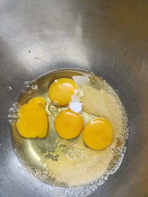 En un bol poner los huevos, la levadura, el bicarbonato y la crema de leche (o la misma medida de aceite).