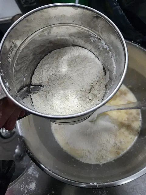 Agregar una tacita de leche (o la misma medida de agua templada) y por último una tacita de harina usando siempre la misma medida del vasito de crema y también tamizándola para que no queden impurezas.