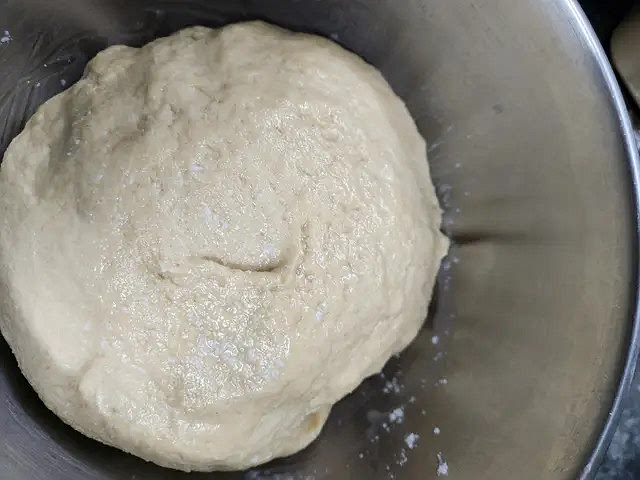 Untar las manos con aceite y comenzar a amasar hasta que quede una masa suave y elástica que no se pega ni en las manos ni en la mesada. Untar el bol con aceite y colocar el bollo de masa.