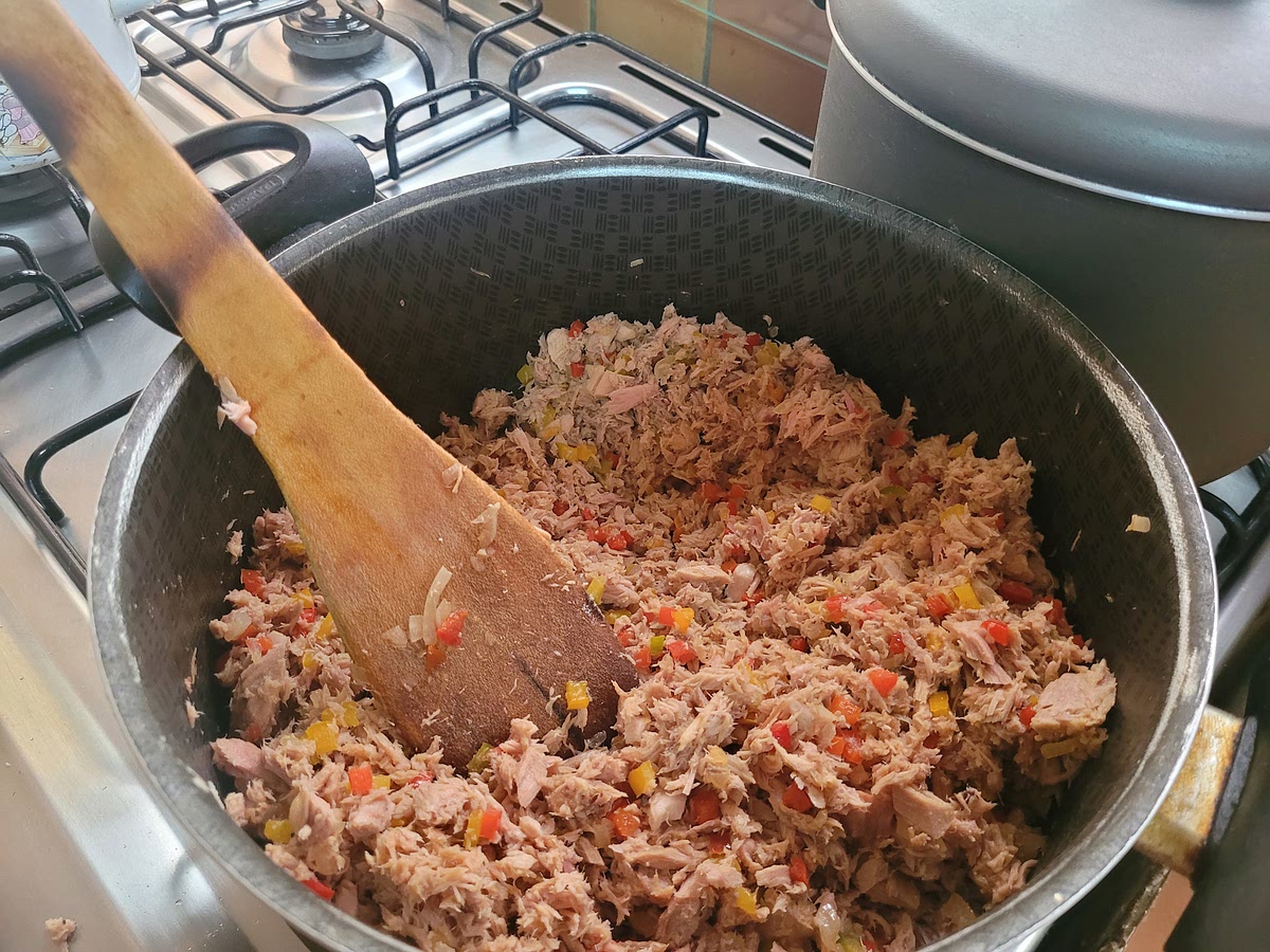 Escurrir bien el atún del jugo de limón y ponerlo a esta mezcla, apagar el fuego de tal forma que el sofrito caliente se mezcle con el atún frío y la temperatura de la mezcla no esté muy alta