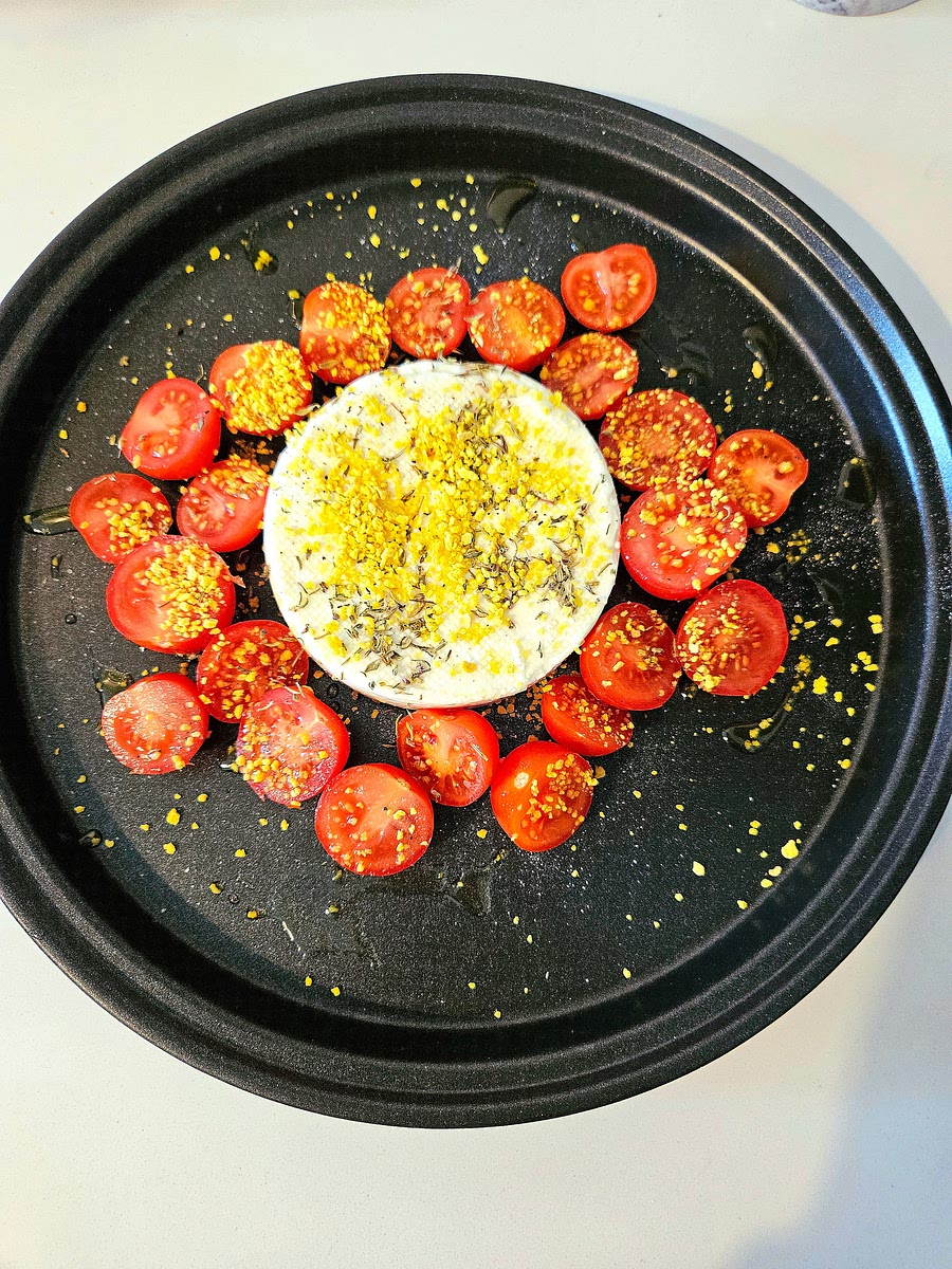 1️⃣ Preparazione del piatto
Disponi il primosale sul un piatto doratore del microonde.
Spolvera la superficie con il pangrattato e il timo.
Taglia i pomodorini a metà e disponili intorno al formaggio.
Condisci con un filo d’olio, sale e pepe.