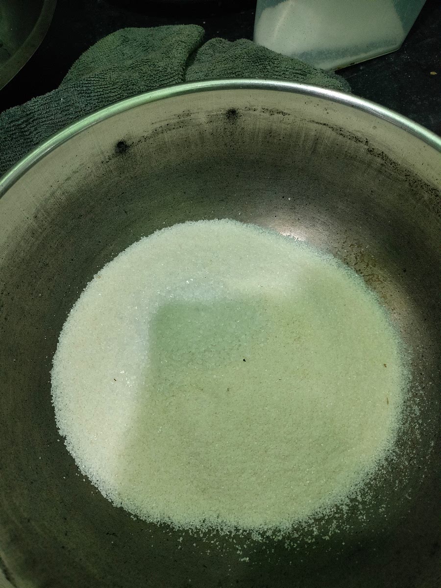 In a utensil, add 2 cups of rava, salt, scraped coconut, and sugar.