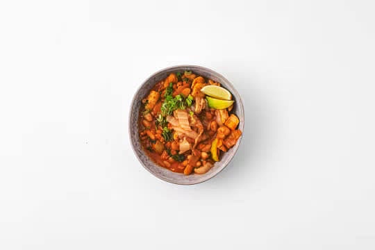 Share the kimchi, butter bean and chicken broth between your bowls. Top with the remaining kimchi and spring onion.
Garnish with the lime wedges.