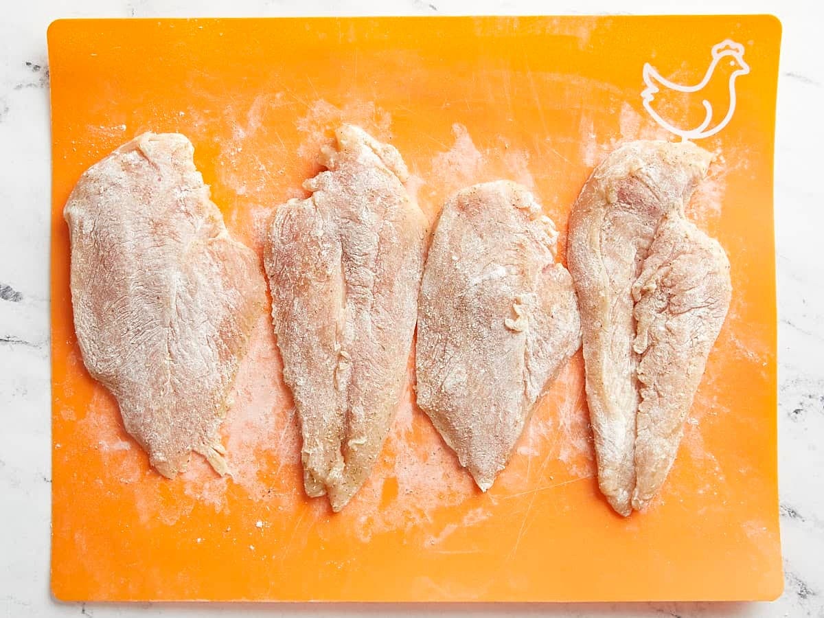 Using a sharp knife, carefully fillet 2 chicken breast into two thinner cutlets (or use thin-cut chicken breasts). Season each breast with 1/2 tsp Italian seasoning, 1/2 tsp salt, and 1/4 tsp freshly cracked black pepper. Then sprinkle 1/4 cup all-purpose flour over both sides of the chicken breasts and rub it in until the chicken is evenly coated.