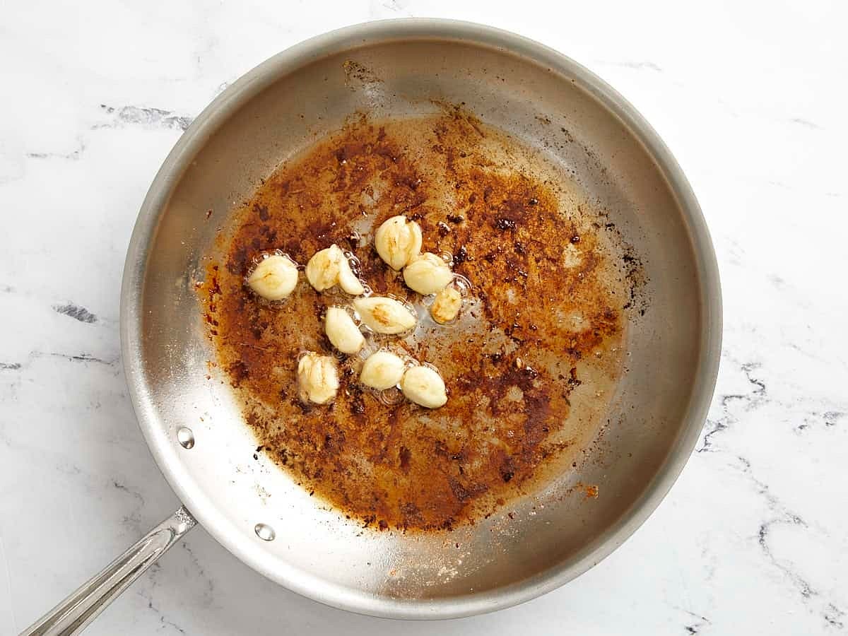While the chicken is cooking, peel the garlic cloves from 1 whole head of garlic. Then carefully smash them with the side of a large chef’s knife by pressing down on the side of the knife with the heel of your hand. Once the chicken is removed, to the same skillet add the remaining 1 Tbsp of butter, then add the garlic cloves. Turn the heat down to medium-low and sauté the garlic for 3 minutes or until lightly browned and fragrant. Make sure to stir the garlic frequently to prevent it from burning.