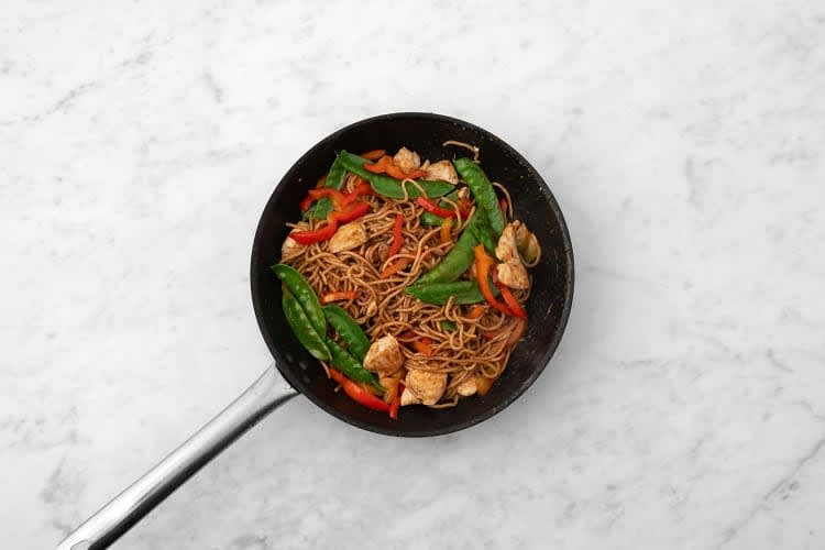 Next, add the pepper and pea pods to the chicken pan. Fry, 3-4 mins. Stir in the bulgogi and soy. Fry, 1-2 mins.
Add the cooked noodles to the pan. Toss to coat and warm through, 1-2 mins. Add a splash of water if it's a bit dry.