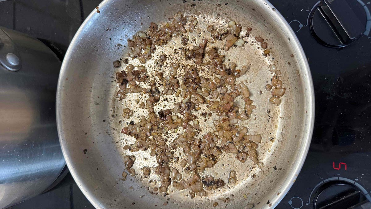 Une fois le jus disparu et les échalotes ramollies et colorées, remettre le mélange saucisse et champignons dans la poêle.