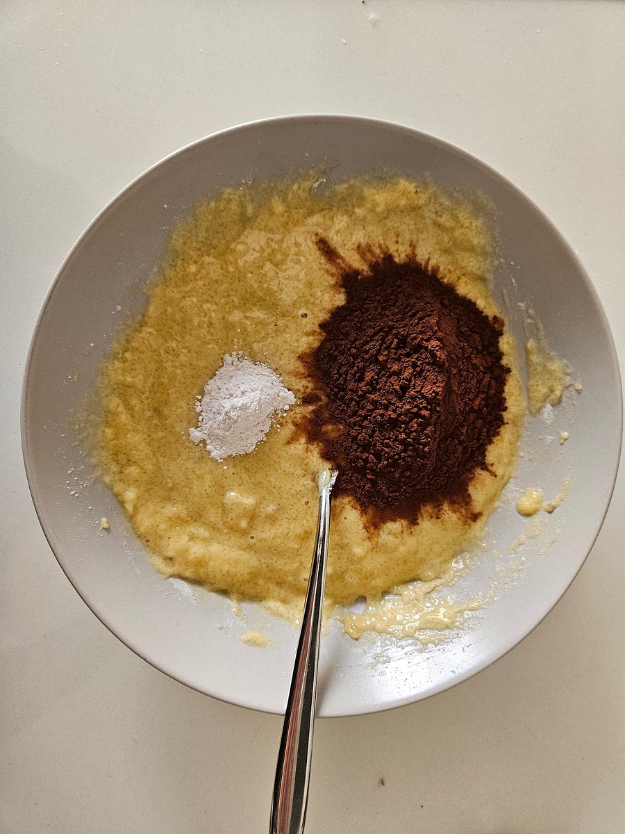 3️⃣ Ora butta dentro in questo ordine: la farina, lo zucchero, il cacao amaro e il lievito. Mescola ogni volta, sempre armato solo della tua forchetta.
