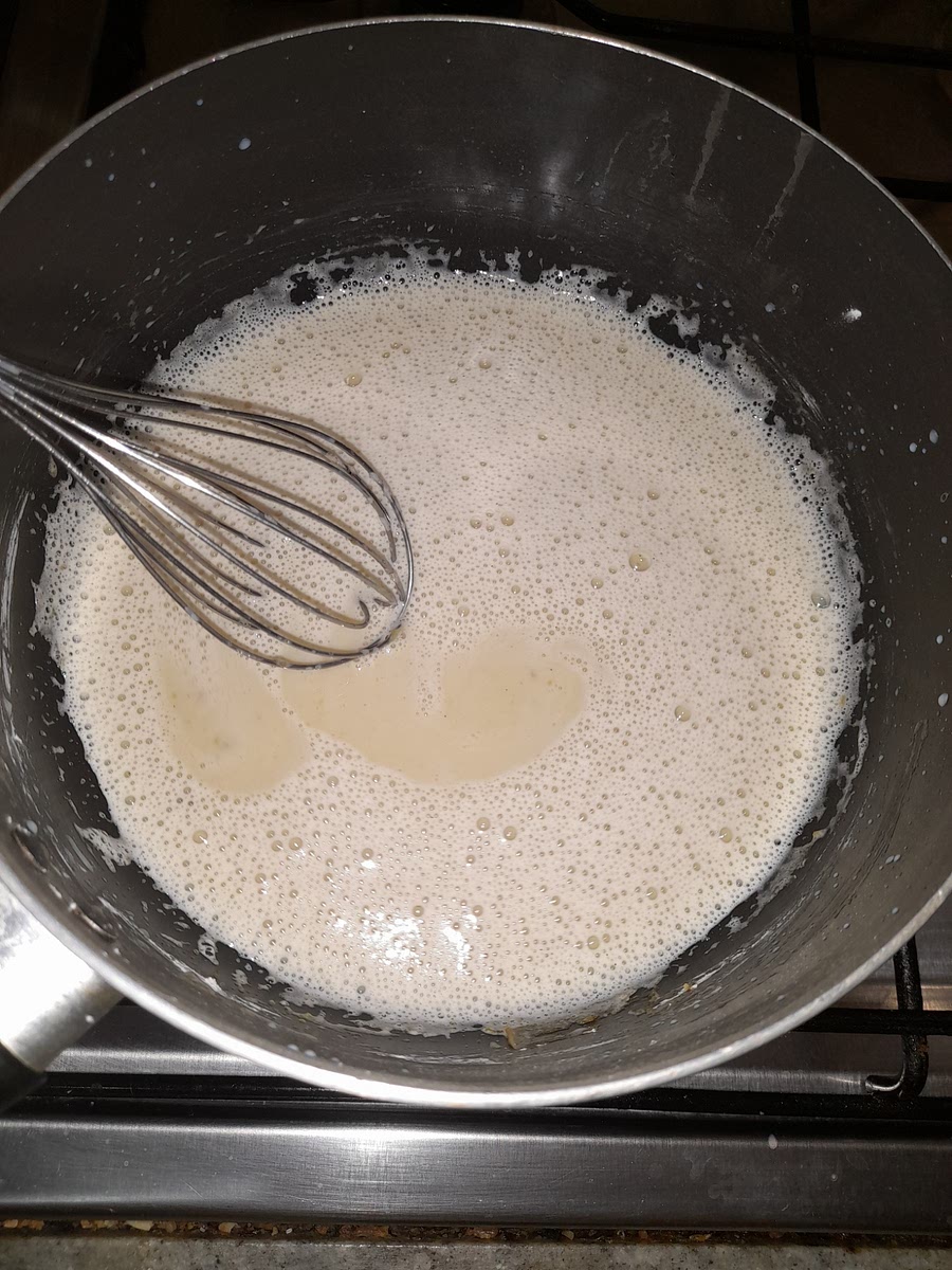 Agregar la leche caliente poco a poco a la mezcla de yemas, batiendo constantemente.