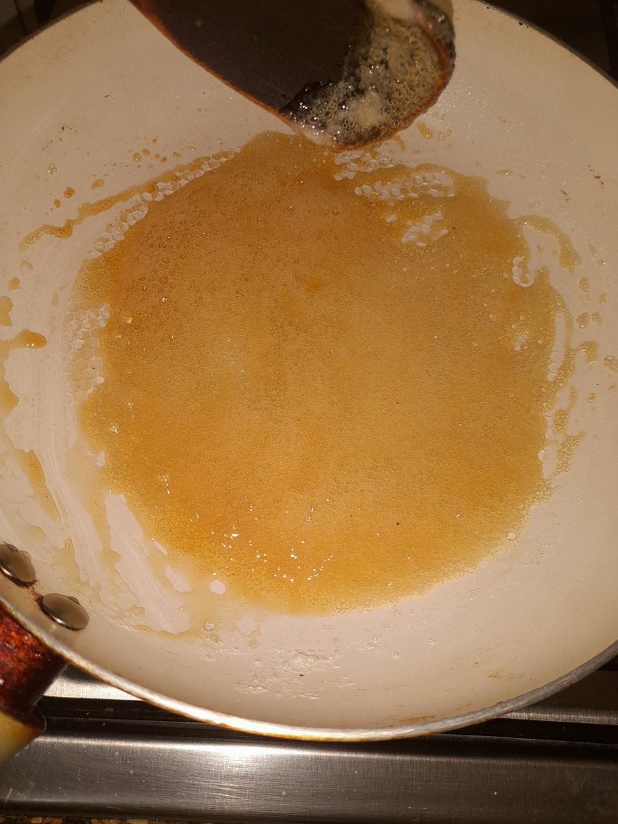 En una sartén, calentar el azúcar con el agua hasta formar un caramelo dorado.