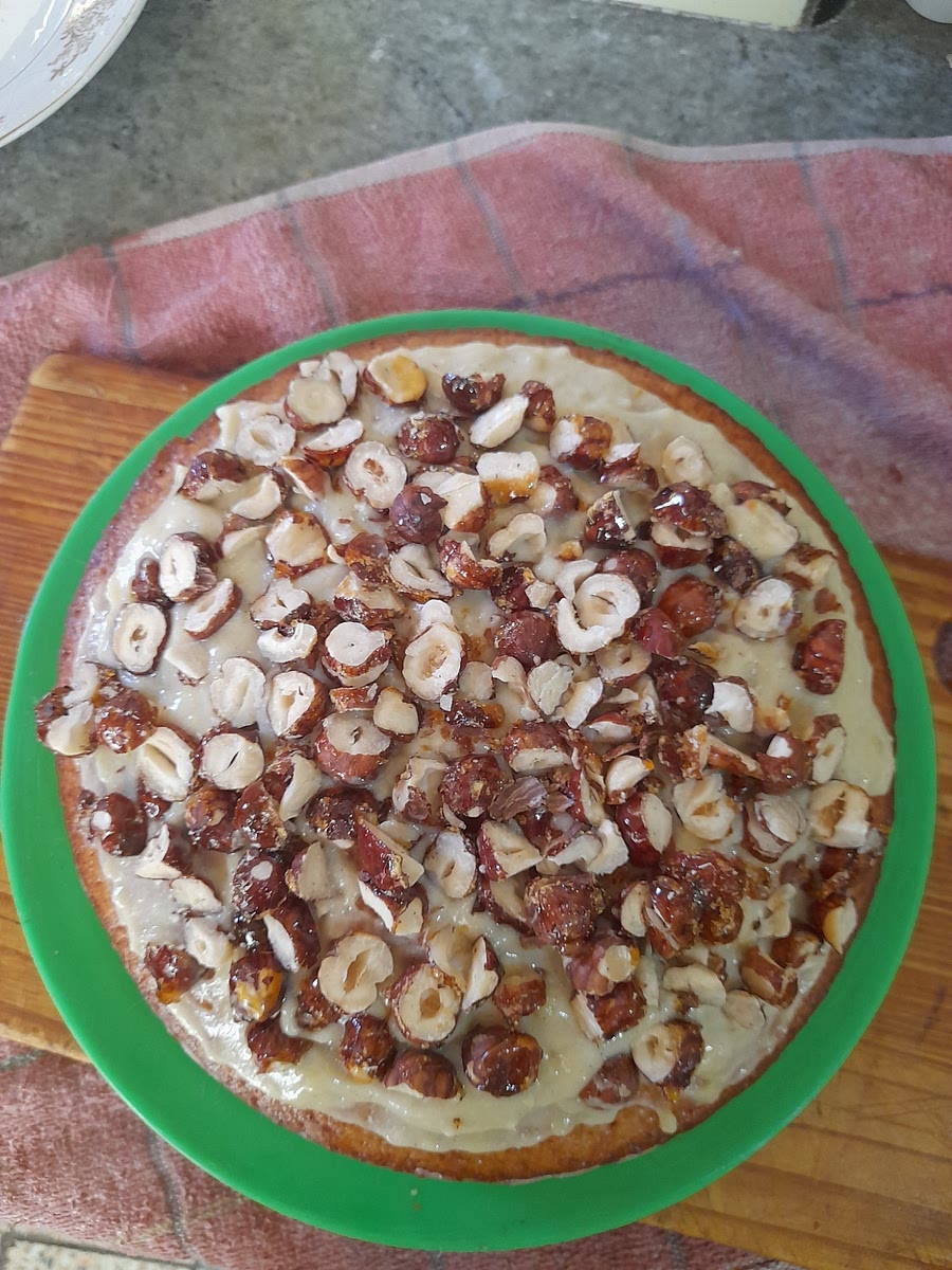 Tapar con la otra mitad del bizcocho y decorar con más crema y avellanas por encima.