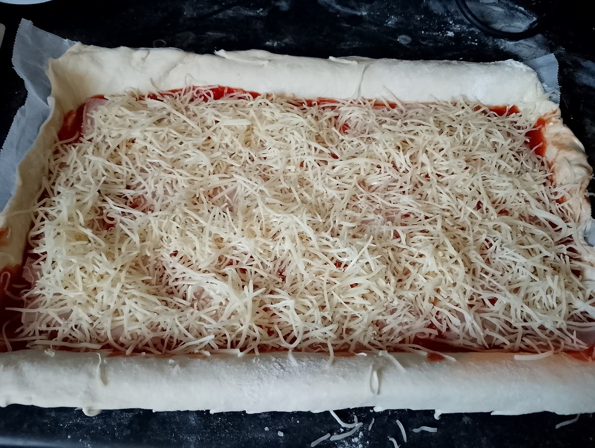 Ensuite étaler la pâte, la mettre dans le plat du four et y étaler de la sauce tomate, couper 4 tranche de jambon en morceaux et les mettre sur la sauce tomate et pour finir étaler un sachet de gruyère sur toute la surface.