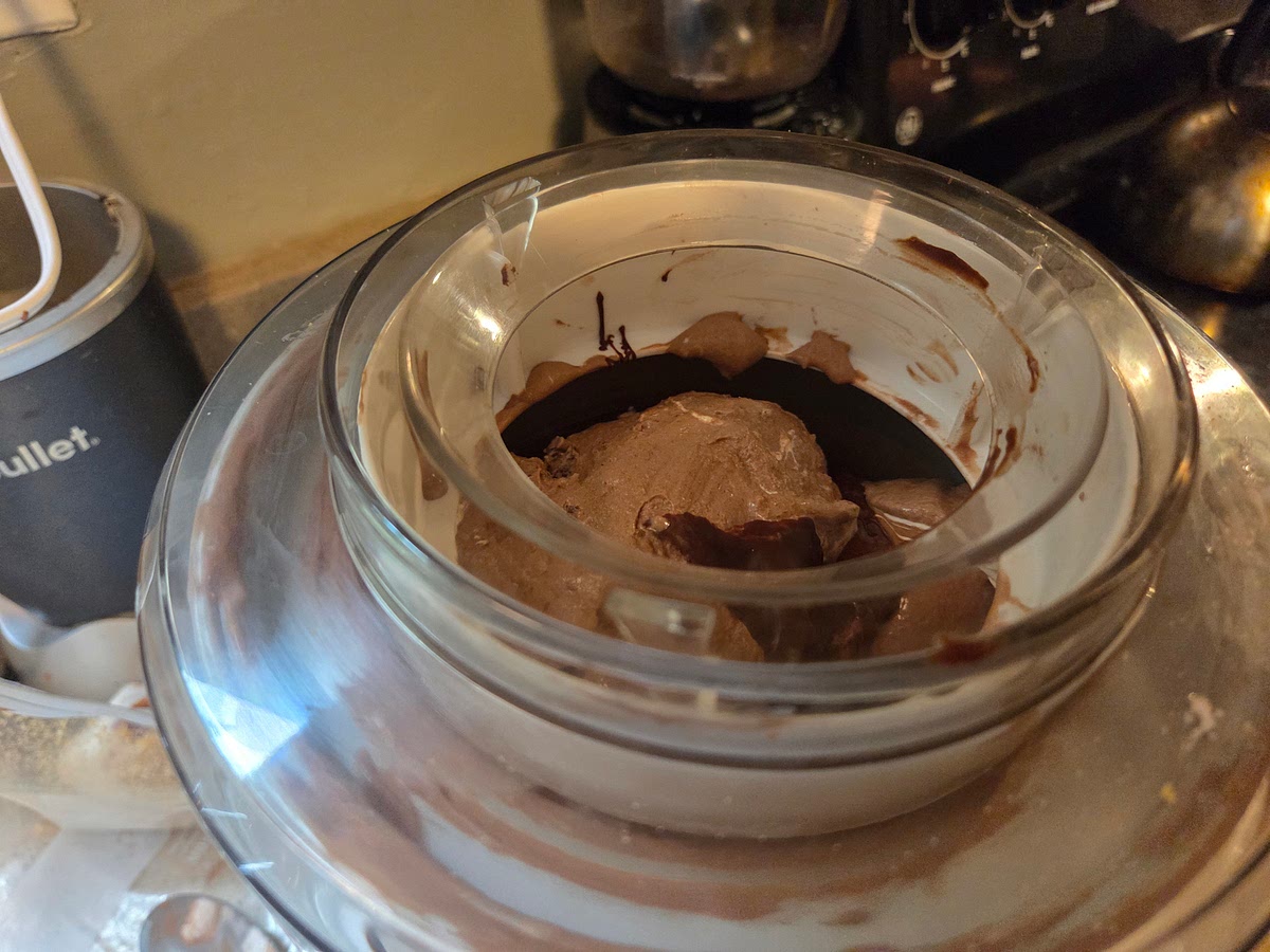 Five minutes before mixing is completed, gradually add the marshmallow cream, one spoonful at a time. Once mixed, add the crushed graham crackers and melted chocolate, one at a time, through the top and let mix in completely.