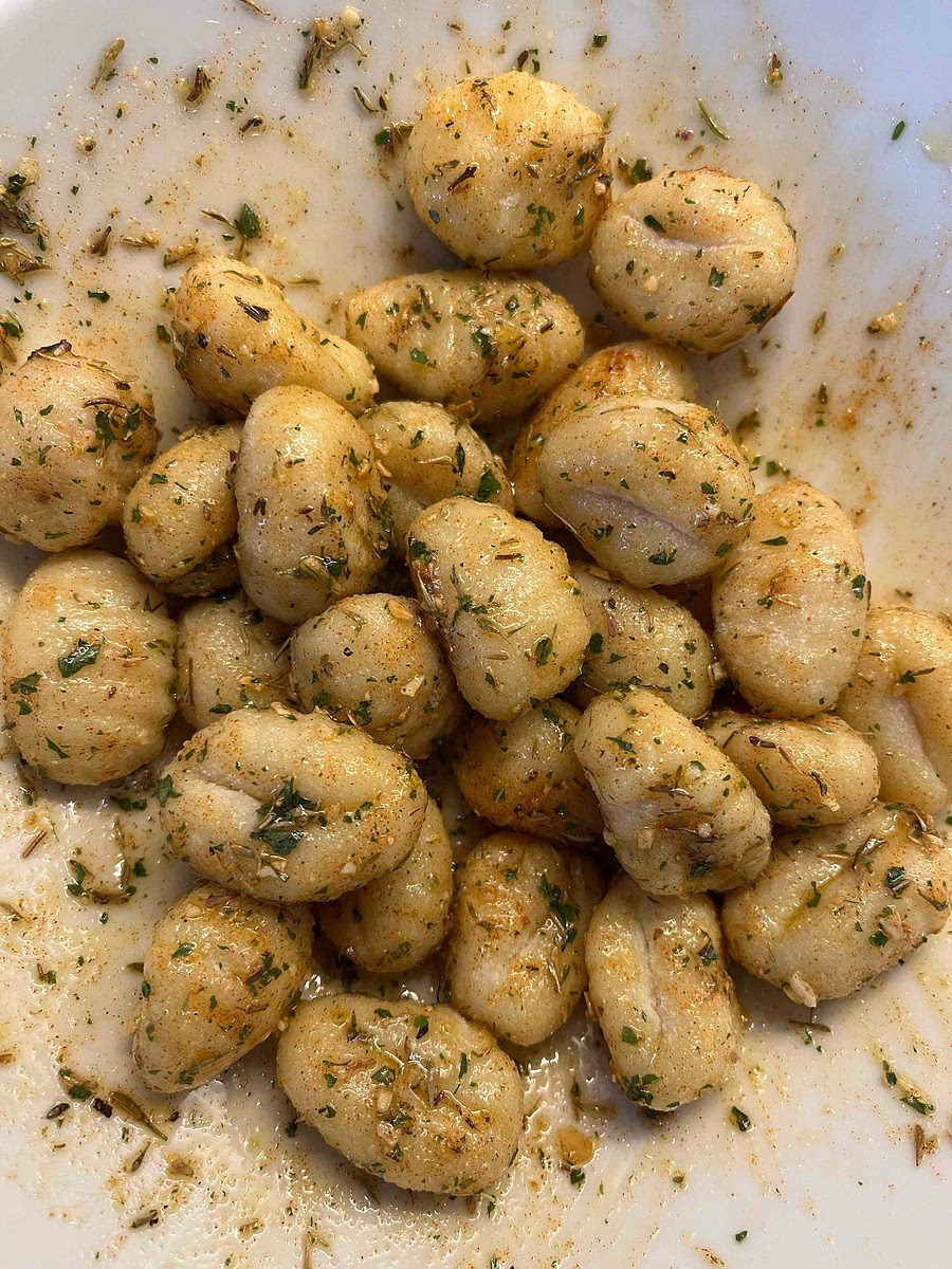 In a bowl ad the gnocchi, seasoning, herbs and spices. Add the extra virgin olive oil and mix well, making sure all sides are coated.
