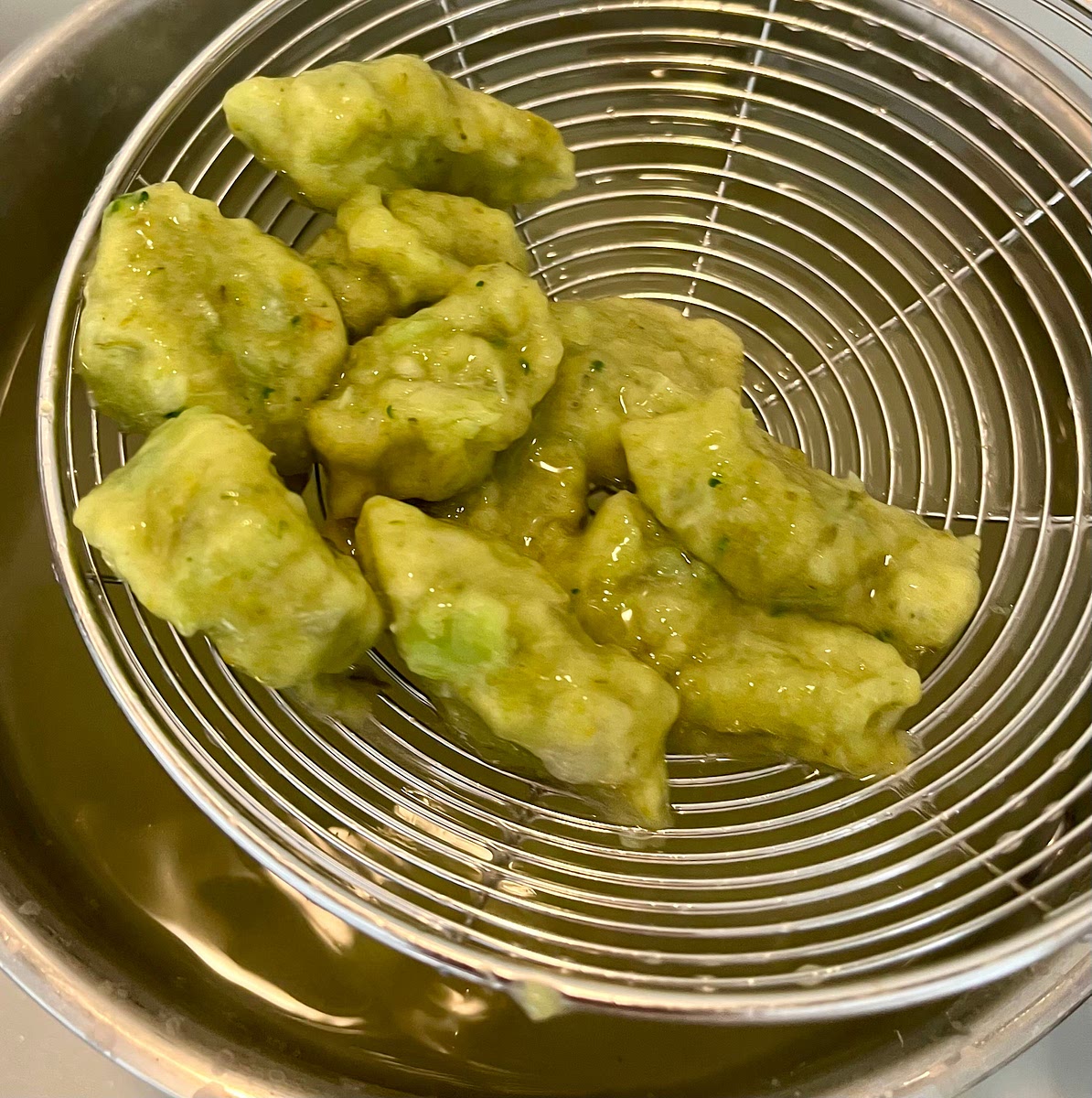 Slowly keep cutting gnocchi until the first one floats to the surface. Put the bag and scissors to the side , and fish the gnocchi with the slotted spoon or sieve as they float to the surface, and put them on the plate. Once you fished them all, get the bag and scissors and repeat the process until all gnocchi are cooked and on the plate.