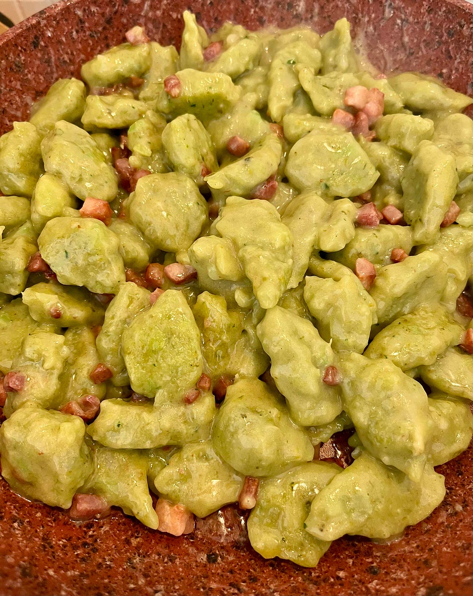 Put the frying pan with the pancetta and butter back on medium heat and add 5 tbsp of cooking water. As it heats up, it will start bubbling and after about a minute the mix of butter and water will have mixed making a creamy emulsion. Drop in the gnocchi and toss them until they are fully coated and the pancetta has evenly distributed.