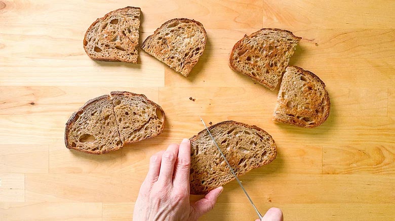 Transfer the toast to a cutting board and cut into halves.