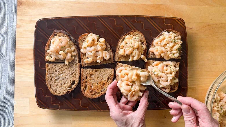 Top the toast with the shrimp salad.