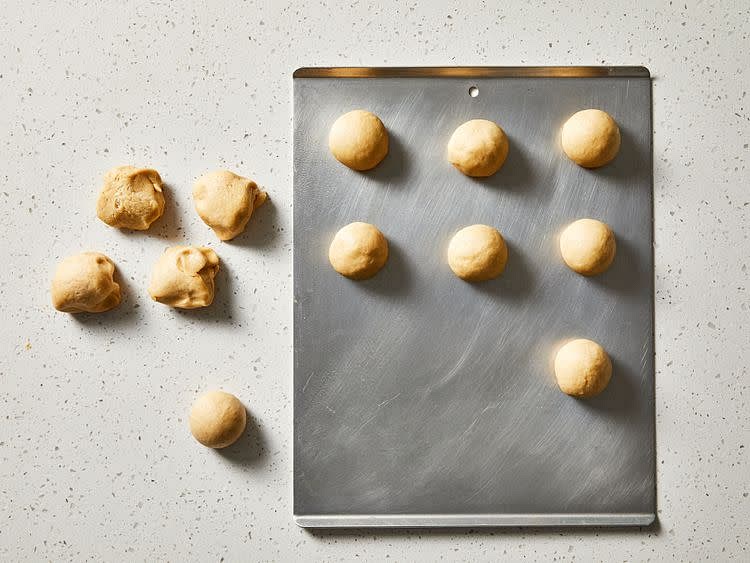 Divide dough into 12 equal pieces. Shape into balls and place 3 inches apart on a greased cookie sheet.