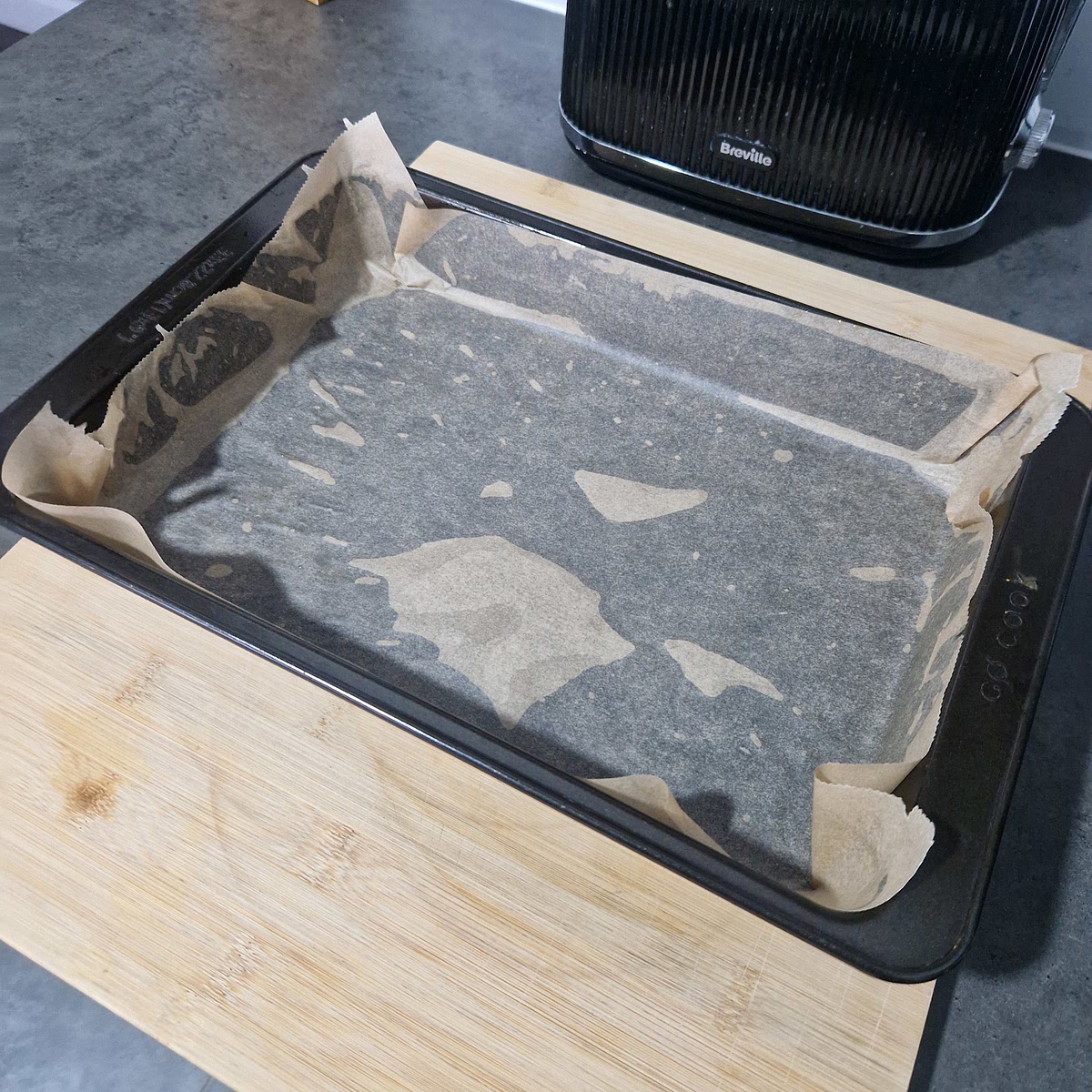 Get a baking tray and use olive oil to stick the baking sheet to the baking tray.