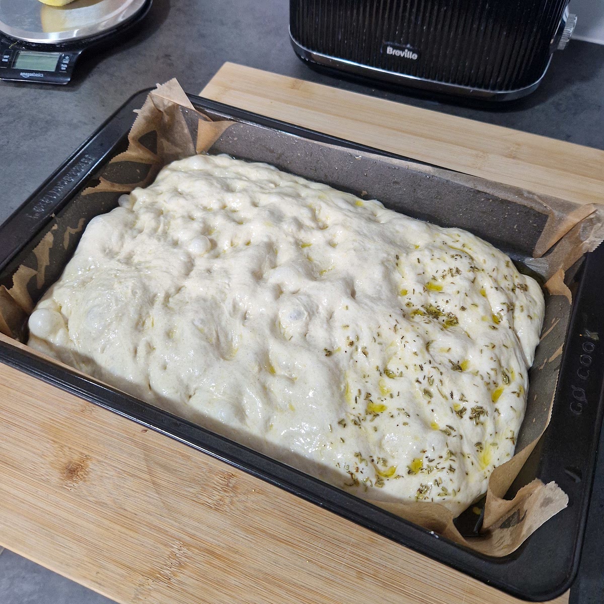 Using a basting brush, paint the rosemary and thyme mix evenly across the dough.
