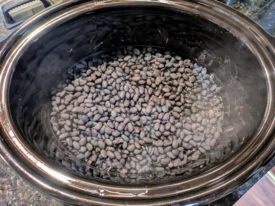 The night before, soak your dry beans with 5 cups (1,200 g) water and 1 tbsp (18 g) salt. In the morning, discard the water, and add your beans to a large slow cooker. Add 1 tsp (6 g) salt and 3 cups (720 g) water. Cover with a lid, and cook on low for about 8 hours, or until the beans are tender and the water is absorbed. This is just my Slow Cooker Dried Beans Recipe