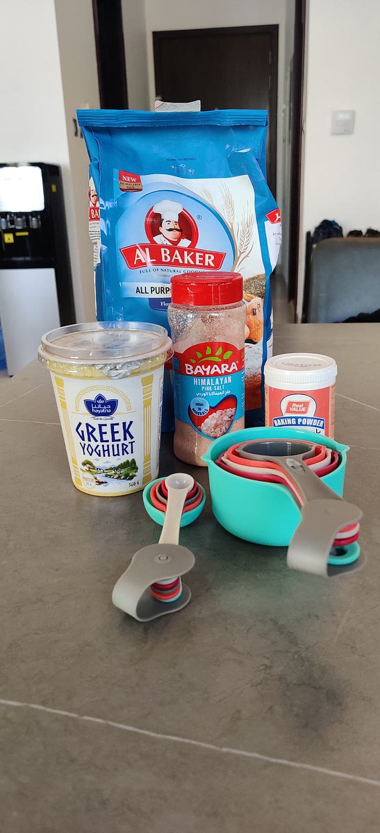 In a large mixing bowl, combine all-purpose flour (2 cups), salt (1/4 teaspoon), baking powder (2 teaspoons), and plain Greek yogurt (1 1/2 cups). Mix until a dough begins to form.