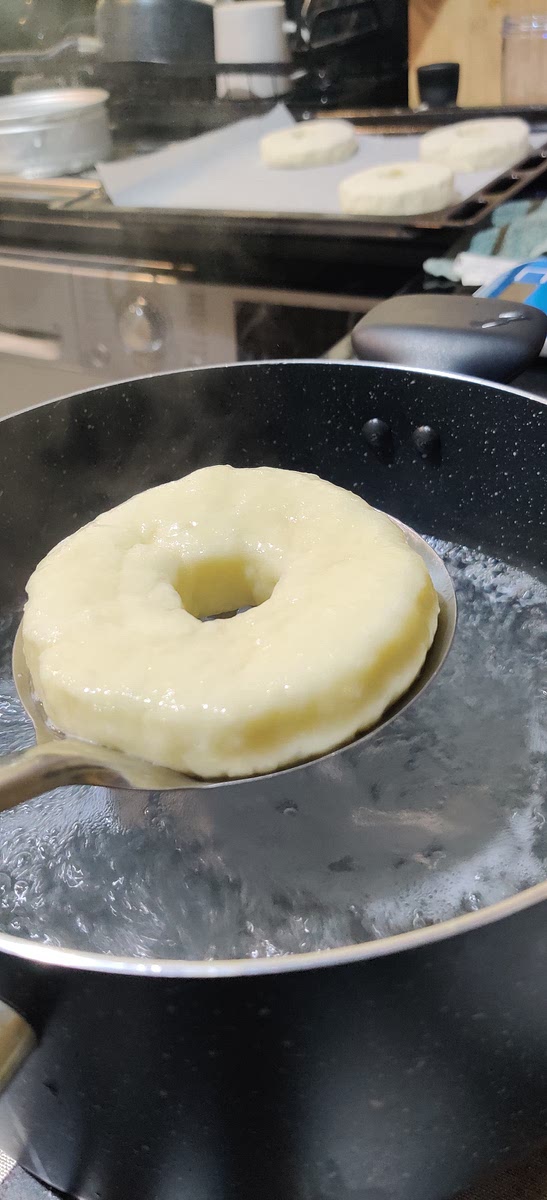 Bring a pot of water to a gentle boil. Blanch each bagel in the hot water for about 30 seconds per side.