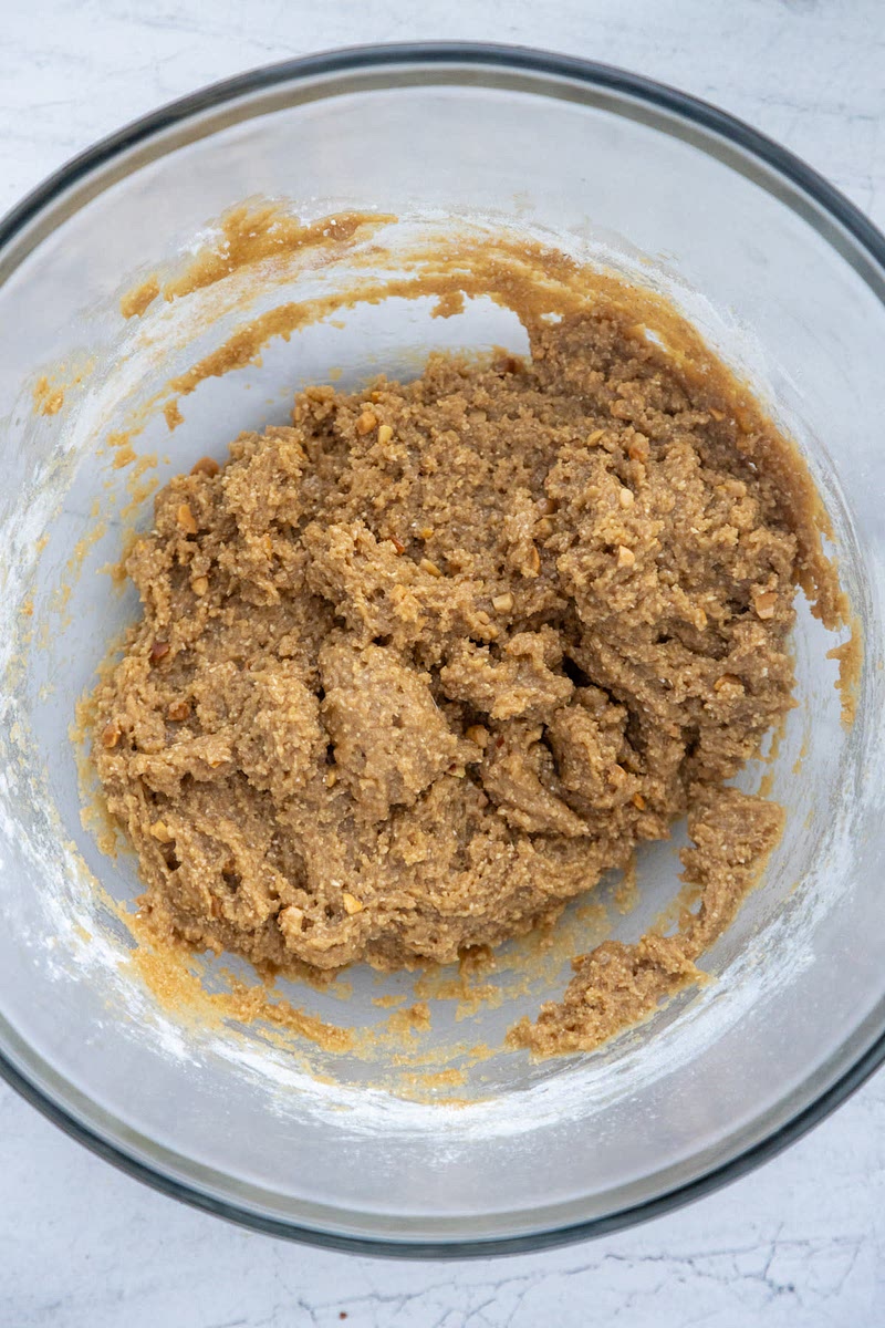 Slowly mix the dry ingredients into the wet until fully combined. Then, fold in chocolate chips & gems.