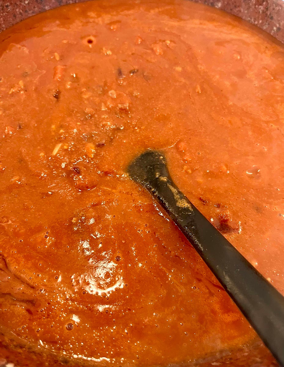 Add the tomato paste and mix to dissolve. Then add the chopped tomatoes, passata and peanut butter and mix well.