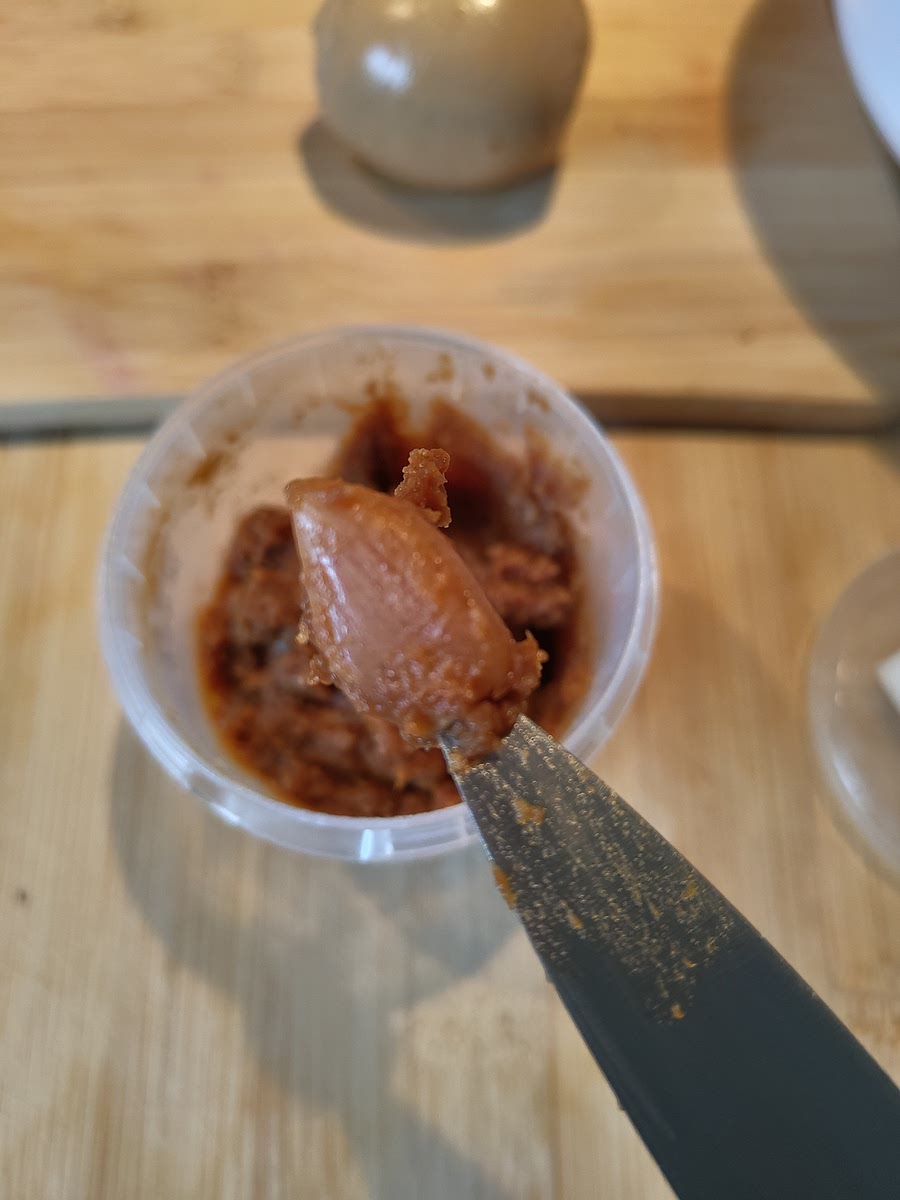 Move the garlic to your fridge to slowly ferment further. After 6 weeks, test and taste a clove to see if it's to your taste and ready to use. (Just cut it up and put it in a noodle soup or on a sandwich or at the last moment in a stir fry.